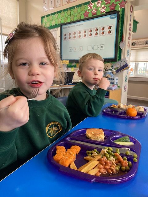 Two children eating a school meal