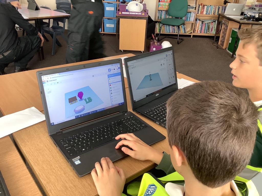 Two children operating laptops to create 3D images