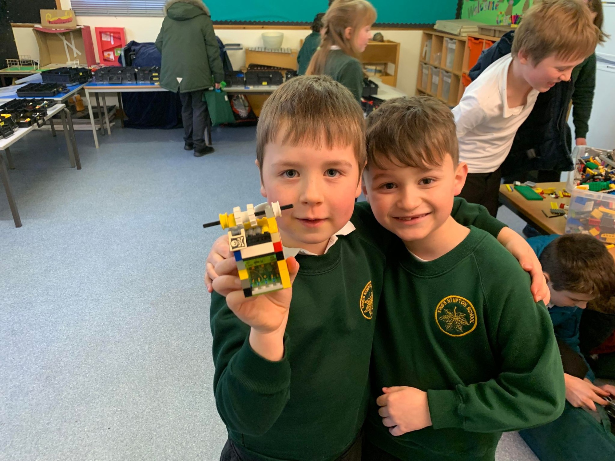 Two children, one holding up a Lego creation
