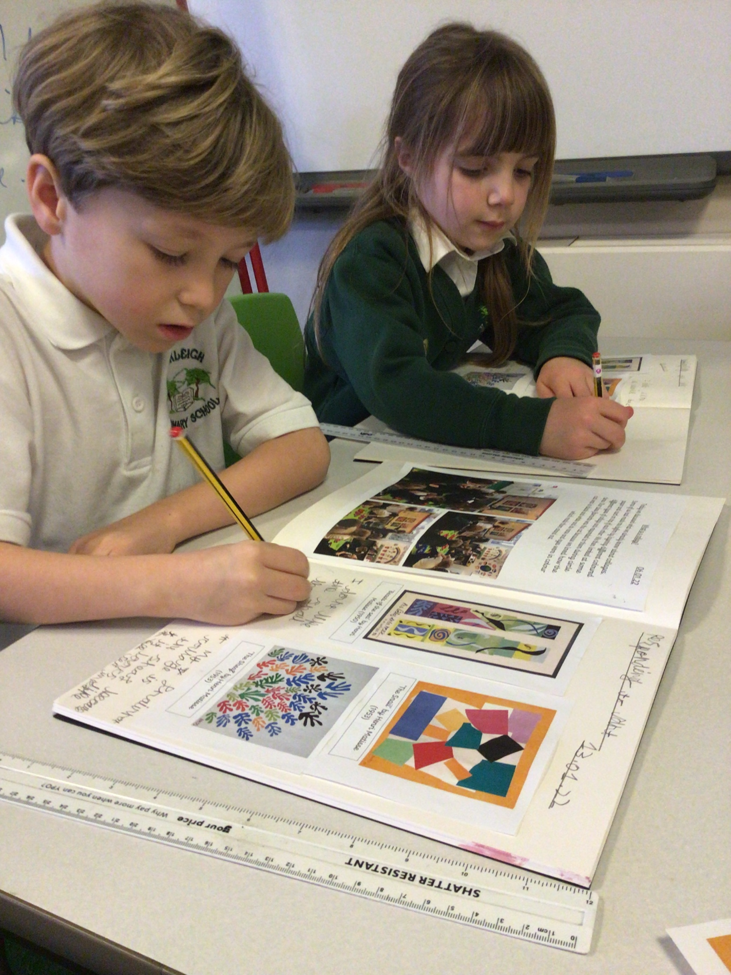 Two children writing in school work books